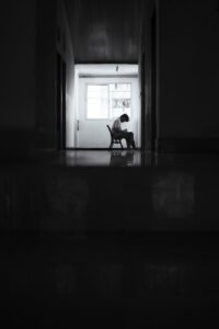 silhouetted person in dimly lit interior corridor
